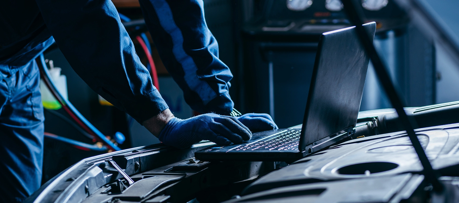 primo-piano-mani-auto-elettricista-utilizzando-computer-portatile-diagnostica-sezione-slider-autoriparazioni-medina